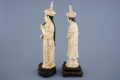 Een groot paar Chinese ivoren keizersfiguren op houten sokkel, ca. 1900