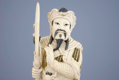 Een Chinese ivoren figuur van een strijder op houten sokkel, eind 19e eeuw