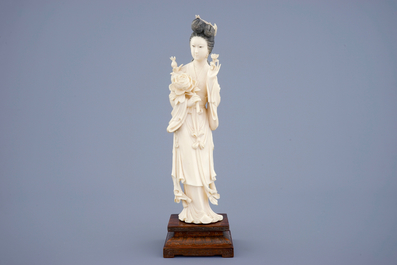 A large Chinese carved ivory figure of Guanyin on wooden base, early 20th C.