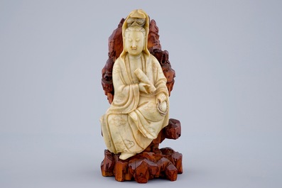 A fine figure of a Guanyin in soapstone on a wooden base, 18/19th C.