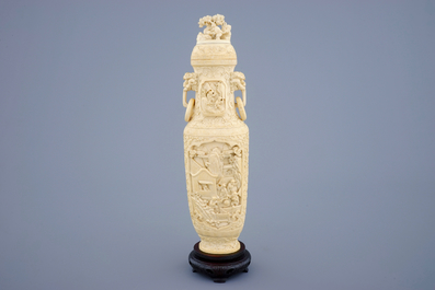 Un vase et son couvercle en ivoire sculpt&eacute; sur socle en bois, d&eacute;but du 20&egrave;me