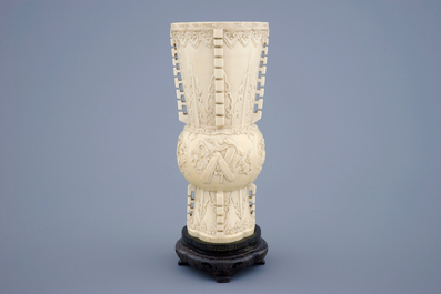 A Chinese carved ivory vase of archaic form on a wooden base, 19th C.