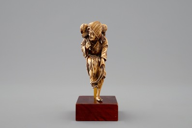 A Japanese ivory okimono of a lady with dogs, Meiji, 19th C.