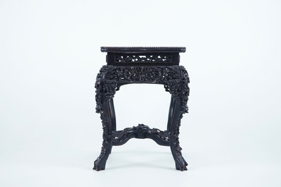 An intricately carved square Chinese wood stand with marble top, 19th C.