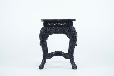 An intricately carved square Chinese wood stand with marble top, 19th C.