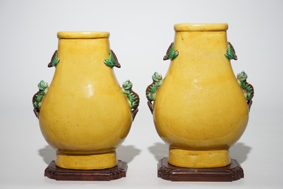 A pair of Chinese yellow glazed hu-shaped vases on stand, 19/20th C.