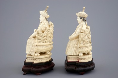 Een paar Chinese ivoren keizersfiguren op troon op houten sokkel, ca. 1900