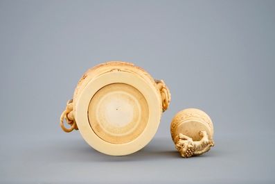 A Chinese carved ivory vase and cover on a wooden base, early 20th C.