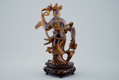 A Chinese carved tiger's eye figure of Guanyin on wooden base, 19/20th C.