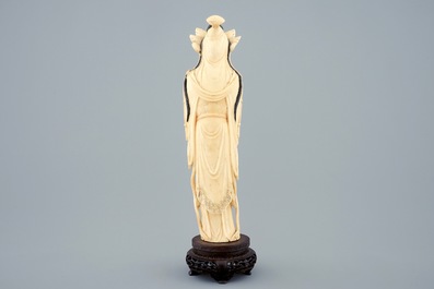 Een grote Chinese ivoren figuur van een Guanyin op houten sokkel, begin 20e eeuw