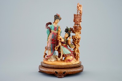 Un groupe polychrome en ivoire sculpt&eacute; sur socle en bois, 19&egrave;me