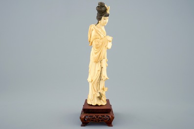 A Chinese carved ivory figure of a lady with hand drum on wooden base, early 20th C.