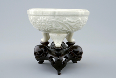 An octagonal Chinese celadon tripod censer on carved wooden base, impressed Qianlong mark, 19th C.
