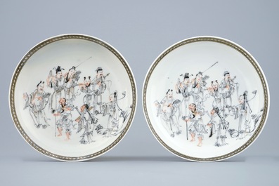 A pair of Chinese grisaille and gilt cups and saucers with immortals, Qianlong, 18th C.