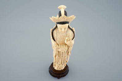 Een grote Chinese ivoren figuur van een Guanyin op houten sokkel, begin 20e eeuw