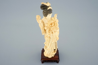 A Chinese carved ivory figure of a lady on wooden base, early 20th C.
