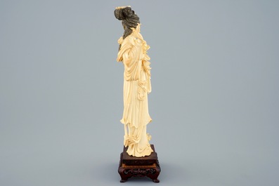 Une figure d'une femme aux fleurs en ivoire sculpt&eacute; sur socle, Chine, d&eacute;but du 20&egrave;me