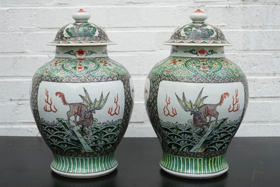 A pair of Chinese famille verte vases and covers with mythical beasts, 19/20th C.