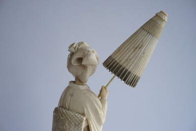 A Japanese carved ivory okimono of a lady holding a parasol, 19th C.