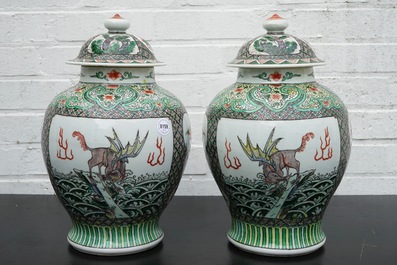 A pair of Chinese famille verte vases and covers with mythical beasts, 19/20th C.