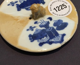 Une th&eacute;i&egrave;re et son couvercle en porcelaine de Chine bleu et blanc sur fond caf&eacute; au lait, Kangxi