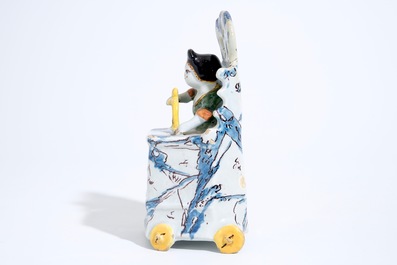 A Dutch Delft polychrome group of a child seated on a toilet, 18th C.