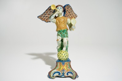 A polychrome Delft style allegorical figure of Fame in the shape of a putto with trumpet, prob. France, 19th C.