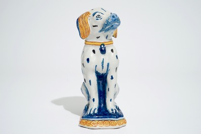 A polychrome Dutch Delft model of a seated dog, 18th C.