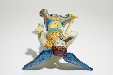 A polychrome Delft style allegorical figure of Fame in the shape of a putto with trumpet, prob. France, 19th C.