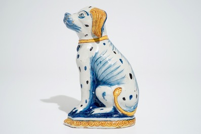 A polychrome Dutch Delft model of a seated dog, 18th C.