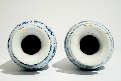 A pair of Dutch Delft blue and white cylindrical vases with tulips and flower scrolls, 17/18th C.