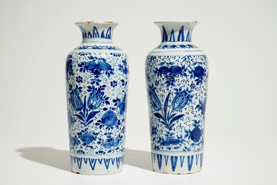 A pair of Dutch Delft blue and white cylindrical vases with tulips and flower scrolls, 17/18th C.