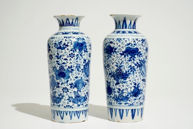 A pair of Dutch Delft blue and white cylindrical vases with tulips and flower scrolls, 17/18th C.