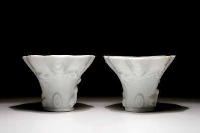 A pair of blanc de Chine relief decorated libation cups, Kangxi