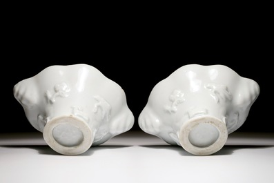 A pair of blanc de Chine relief decorated libation cups, Kangxi