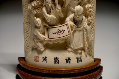 Een Chinese ivoren plaquette met onsterfelijken op houten sokkel, 2e kwart 20e eeuw