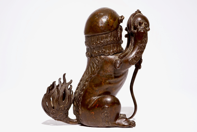 A Chinese lacquered bronze censer modelled as a buddhist lion with a brocade ball, Ming