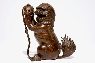 A Chinese lacquered bronze censer modelled as a buddhist lion with a brocade ball, Ming