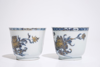 A pair of Chinese blue, white and gilt cups and saucers, Qianlong
