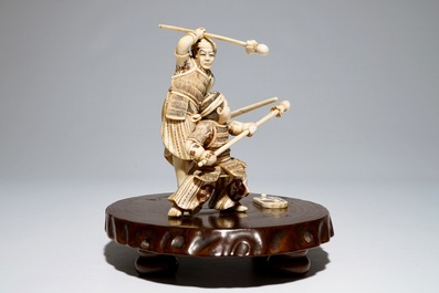 A Japanese ivory group of a warrior and his pupil, on a wooden base, Meiji, signed