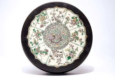 A Chinese famille verte on biscuit lotus-shaped dragon plaque mounted in a wooden stand, Kangxi