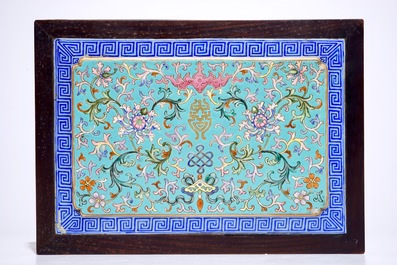 A Chinese famille rose enamel tile plaque mounted in a wood stand, 19th C.