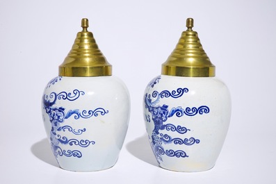 A pair of Dutch Delft blue and white tobacco jars with brass covers, 19th C.