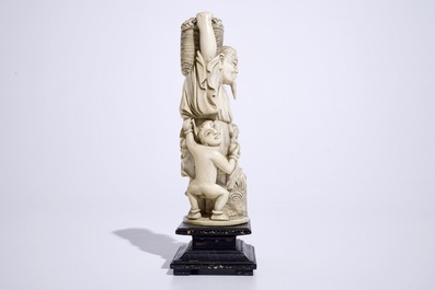 A Chinese ivory group of a peach picker on wooden base, early 20th C.