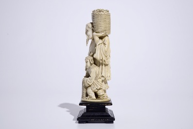 Un groupe en ivoire sculpt&eacute; d'un cueilleur de p&ecirc;ches sur socle en bois, Chine, d&eacute;but du 20&egrave;me