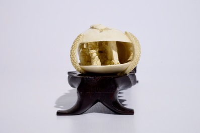 Un groupe en ivoire sculpt&eacute; en forme d'un coquillage sur socle en bois, d&eacute;but du 20&egrave;me