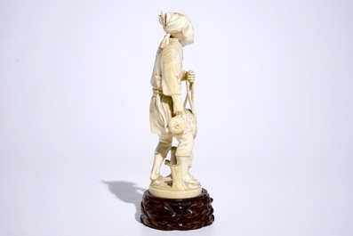 Un okimono en ivoire figurant un p&ecirc;cheur sur socle en bois, Japon, Meiji, 19&egrave;me, sign&eacute;
