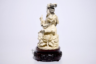 Un mod&egrave;le d'une femme jouant la fl&ucirc;te en ivoire sculpt&eacute; sur socle en bois, Chine, d&eacute;but du 20&egrave;me