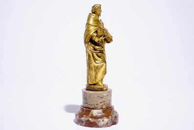 A gilt bronze model of a saint on a later marble base, 17th C.