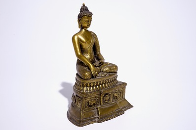 A gilt bronze model of Buddha seated on a throne, Nepal or Tibet, 19/20th C.